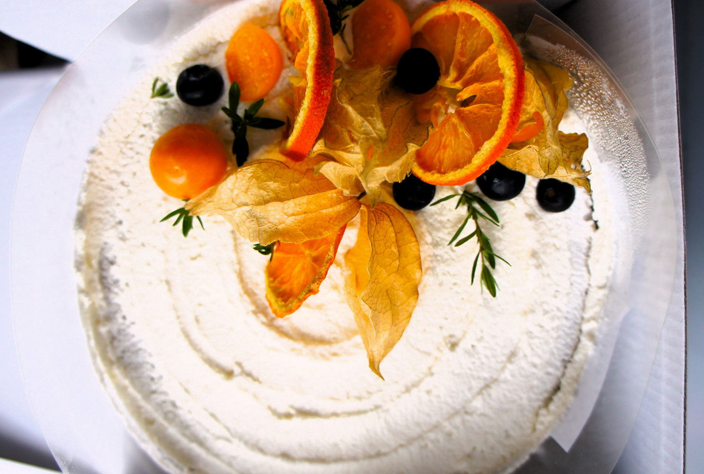 Decorative cake with fruit slices on a white plate