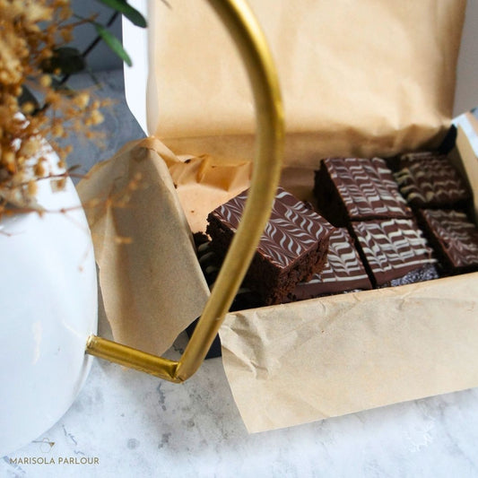 Box of brownies on a marble surface, featuring the brand 'Marisola Parlour'.
